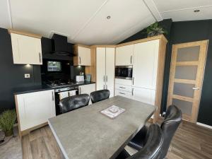 a kitchen with a table and chairs in a room at 16 Lake View, Pendle View Holiday Park, Clitheroe in Clitheroe