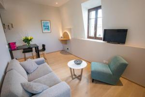 a living room with a couch and a table and a tv at Villa Saint Enogat in Aix-les-Bains