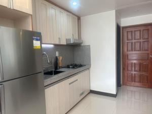 a kitchen with a stainless steel refrigerator and wooden cabinets at 7th Heavens Vacation Home in Banaue