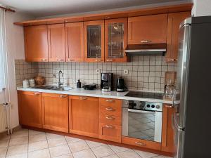 a kitchen with wooden cabinets and a stainless steel refrigerator at Apartment Vita in Bled