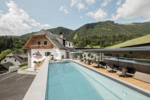 een zwembad op het dak van een gebouw met bergen op de achtergrond bij Rest Apartments & Suiten in Mauterndorf