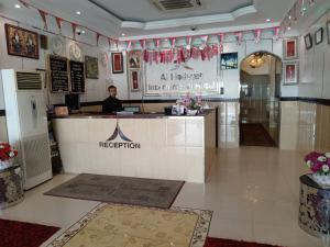Al Hedayet International Hotel في سيب: رجل يجلس في كونتر في مطعم