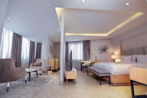 Cette chambre comprend un lit et un bureau. dans l'établissement The Row Residential Hotel, à Addis-Abeba