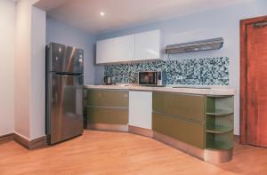 a kitchen with a stainless steel refrigerator and cabinets at The Row Residential Hotel in Addis Ababa
