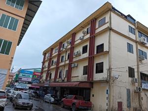 un edificio in una strada cittadina con auto parcheggiate di fronte di OYO 90809 Oriental Hotel a Sarikei