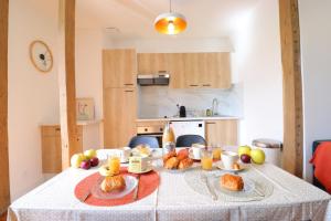 uma mesa com croissants e frutas na cozinha em Le Boho - Charmant T3 - gare à 5 min à pieds em Bergerac