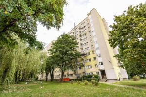 a large building with trees in front of it at Mokotów Orzycka Beige Studio in Warsaw