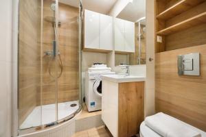 a bathroom with a shower and a toilet and a sink at Mokotów Orzycka Beige Studio in Warsaw