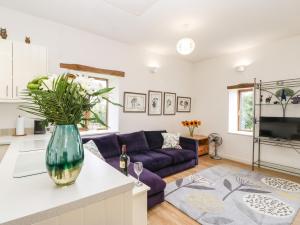 a kitchen and living room with a purple couch at Whinstone in Keisley