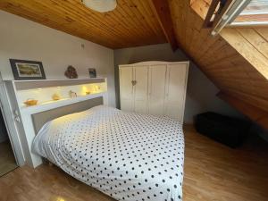 1 dormitorio con 1 cama en el ático en B&B Des Bois Sans Nombre, en Paliseul