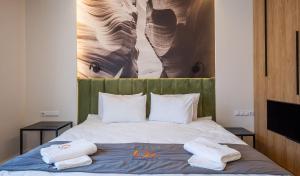 a bedroom with a bed with two towels on it at Olimpia Residence Central Satu Mare in Satu Mare