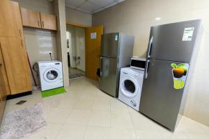 uma lavandaria com 2 frigoríficos e uma máquina de lavar e secar roupa em Budget Rooms With Private Bathroom for 'girls' only in Dubai, Marina em Dubai