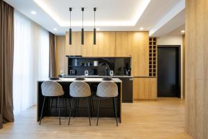 a kitchen with a island with bar stools at Olimpia Residence Central Satu Mare in Satu Mare