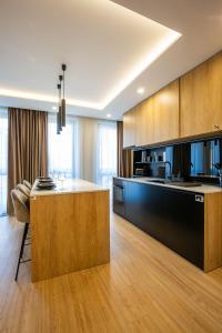 uma cozinha com armários de madeira e uma ilha de cozinha em Olimpia Residence Central Satu Mare em Satu Mare