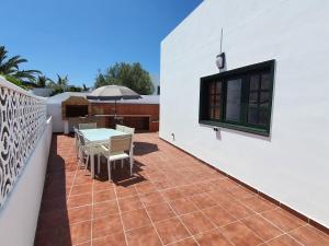 un patio con tavolo e sedie sul balcone. di Casa El Eco del Volcán 1 a Teguise