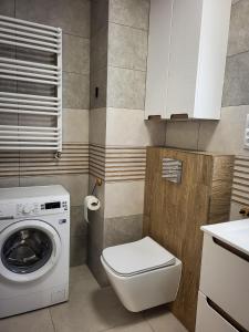 uma casa de banho com um WC e uma máquina de lavar roupa em Apartament Ceglany em Legnica