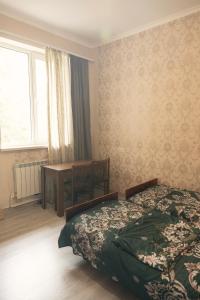 a bedroom with a bed and a table and a window at Комната с видом на горы in Dilijan