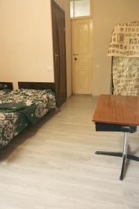 a room with a bed and a table and a door at Комната с видом на горы in Dilijan