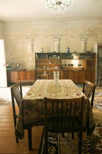 a dining room with a table with chairs and a chandelier at Комната с видом на горы in Dilijan