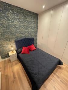 een slaapkamer met een zwart bed met 2 rode kussens bij Lujo en Barrio Salamanca in Madrid