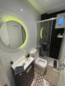 een badkamer met een wastafel, een toilet en een spiegel bij Lujo en Barrio Salamanca in Madrid