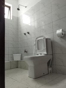 a white bathroom with a toilet and a sink at Volume view Apartments in Mombasa