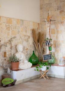 a room with a statue and plants on a shelf at Casa aoom - Casa Vacanze con Sala Yoga e Pilates in San Pietro in Bevagna +49 photos