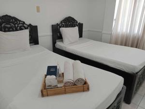 dwa łóżka z ręcznikami i kosz na stole w obiekcie North Shores Inn w mieście Currimao