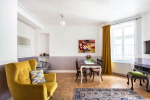 a living room with a yellow chair and a table at GROBLE 19 in Kraków