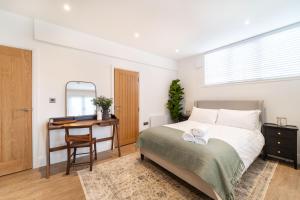 um quarto com uma cama, uma secretária e uma janela em 8 The Quadrant Luxury Apartments - Hoylake em Hoylake