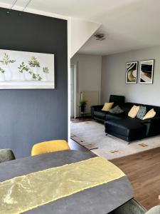a living room with a black couch and a table at Ferienwohnung Teichblick in Priesendorf