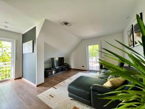 a living room with a green couch and a tv at Ferienwohnung Teichblick in Priesendorf