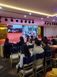 a group of people sitting in chairs in front of a screen at City Hostel Da Nang in Danang