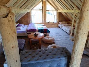 a attic room with two beds and a table at Komovi - Montenegrina Mountain house in Kolašin