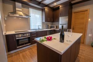 eine Küche mit einer Theke mit einer Flasche Wein und Gläsern in der Unterkunft Casa Visita Ribeira Sacra in Chantada