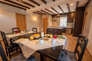 ein Esszimmer mit zwei Tischen und eine Küche in der Unterkunft Casa Visita Ribeira Sacra in Chantada