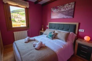 Schlafzimmer mit einem Bett mit rosa Wänden und einem Fenster in der Unterkunft Casa Visita Ribeira Sacra in Chantada + 14 Fotos