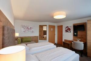 ein Hotelzimmer mit 2 Betten und einem Schreibtisch in der Unterkunft Hotel-Restaurant am Hochfuchs in Eugendorf