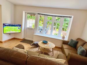 a living room with a couch and a tv at 14 Granite Henge in Looe