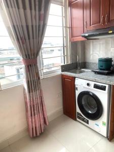 een keuken met een wasmachine en een raam bij Li Homestay 136 Trần Bình, Mỹ Đình, Nam Từ Liêm, Hà Nội in Hanoi