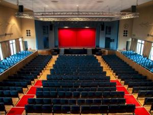 an empty auditorium with a red stage in the background at Pass the Keys Sea Haven Stylish Beach Oasis in Hastings