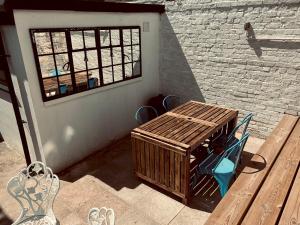 a patio with a wooden table and a window at Pass the Keys Sea Haven Stylish Beach Oasis in Hastings
