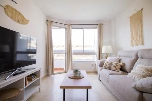 un soggiorno con divano e TV di Vistamarina B308 By IVI Real Estate a Torremolinos