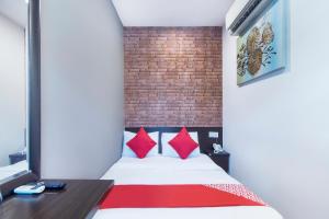 een kamer met een bed met rode kussens bij OYO 876 Hotel Sanctuary in Petaling Jaya