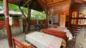 a dining room with a table and benches in a cabin at Садиба над греблею in Kosiv