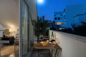 einen Tisch mit Essen und Wein auf einem Balkon in der Nacht in der Unterkunft Downtown Pool House in Faro