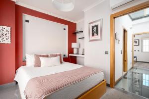 a bedroom with a large bed with red walls at Downtown Pool House in Faro +25 photos