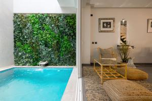 a living room with a pool and a chair and a table at Downtown Pool House in Faro