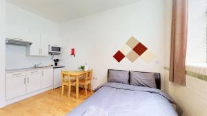 a small bedroom with a bed and a kitchen at Stunning Studio N7 in London
