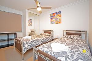 a bedroom with two beds and a ceiling fan at The Pearl in Jurien Bay
